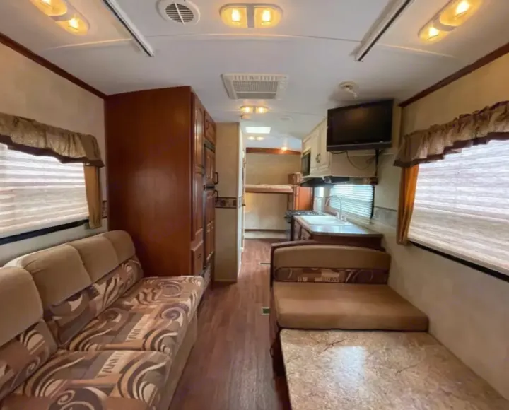 Spacious RV rental interior with living area, kitchen, dinette, and bunk beds. Ideal for your next adventure.. Keystone RV Outback 2010