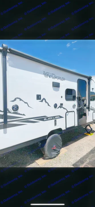 Bright white "Wolf Pup" travel trailer RV rental with mountain decals, ready for adventure.. Forest River Cherokee Wolf Pup Black Label 2022