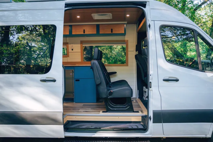 Inside this RV rental: a spacious camper van conversion with a kitchen, comfy seating, and storage, ready for adventure.. Mercedes-Benz Sprinter 2024