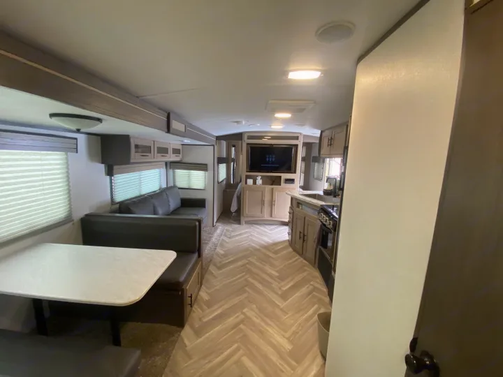 Spacious RV rental interior with dinette, sofa, kitchen, and entertainment area, perfect for travel comfort.. Cruiser RV Shadow Cruiser 2021