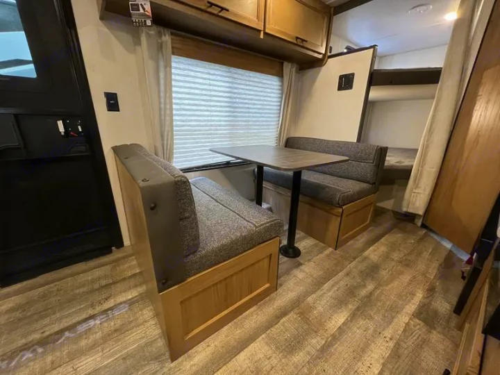 RV rental interior: Dinette seating for meals, with bunk beds for extra sleeping, ideal for road trips.. Forest River Cherokee Grey Wolf Special Edition 2022