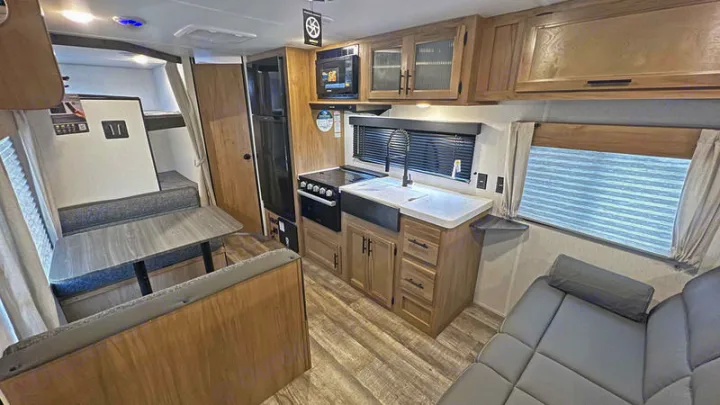 Inside this spacious **RV rental**, a modern kitchenette, dining area, and bunk beds offer comfort for travelers.. Forest River Cherokee Grey Wolf Special Edition 2022