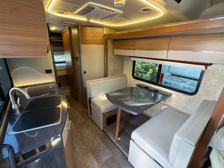 Explore this modern rv rental interior: compact kitchen on the left, inviting dining booth on the right, designed for adventure.. Winnebago View 2017