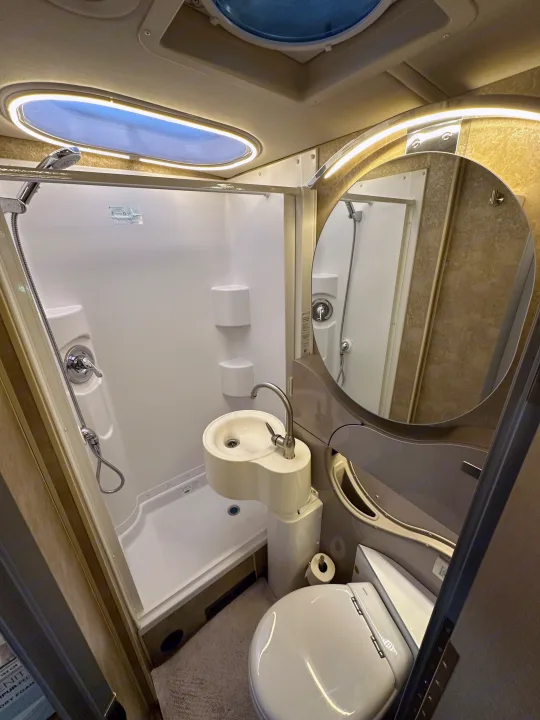 Explore this efficient rv rental bathroom with shower, unique sink, toilet, illuminated mirror, and skylight.. Winnebago View 2017