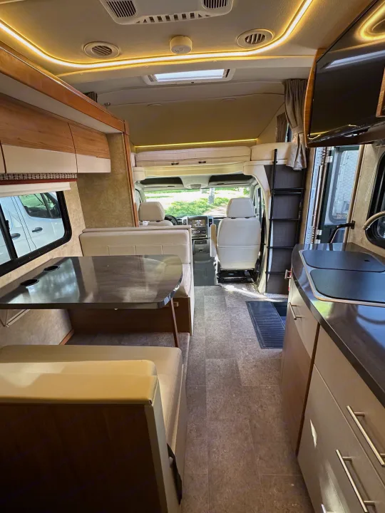 Spacious rv rental interior: dining area, kitchen, and overhead bunk. Perfect for comfortable travel adventures.. Winnebago View 2017