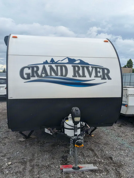Front view of a Grand River travel trailer, perfect for your next RV rental adventure. Features propane tanks & hitch.. Grand River Comfortline 20bh 2022
