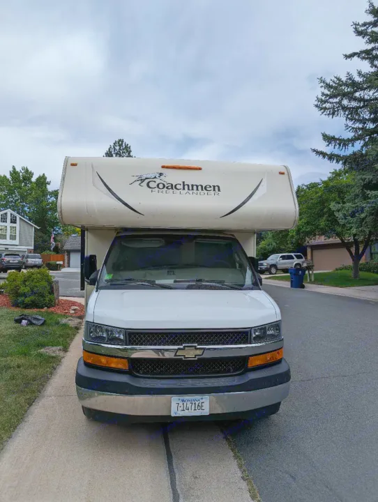 White Coachmen Freelander Class C **rv rental** parked on a street, displaying its Montana license plate.. Forest River Coachmen Freelander 2018