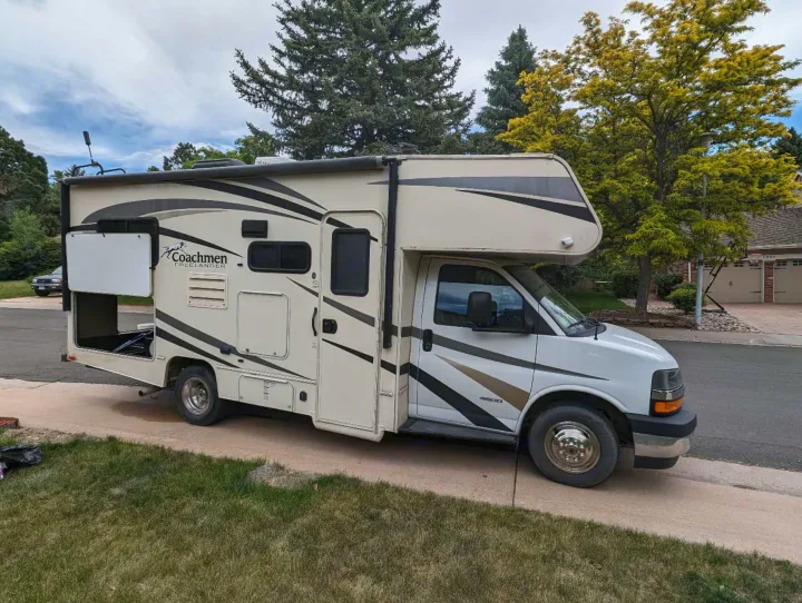 This Coachmen Freelander Class C rv rental, with open side storage, is parked on a suburban driveway, ready for a road trip.. Forest River Coachmen Freelander 2018