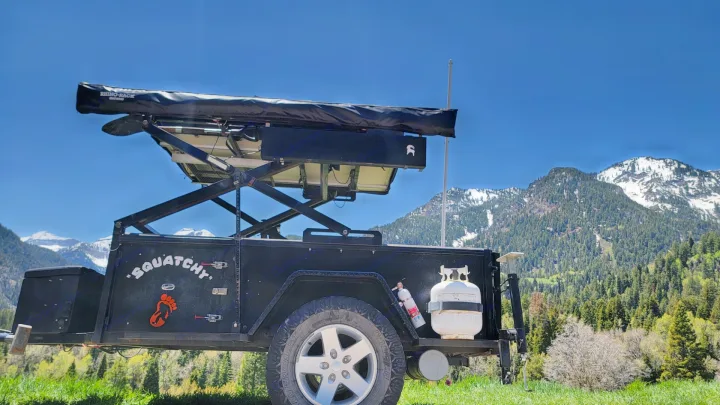 Black off-road camping trailer "Squatchy" with solar & propane, set in mountains. Ideal for an RV rental mountain escape.. Insane Custom Trailers "Squatchy" 2022