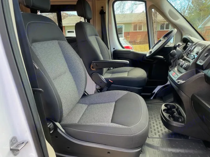Inside an RV rental van: comfortable driver and passenger seats, dashboard, and clean interior, ready for your road trip!. Winnebago Solis 2021