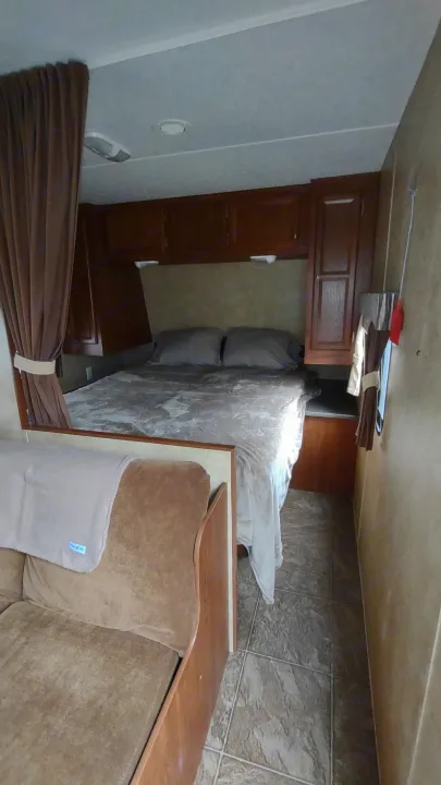 Experience a comfortable RV rental: A compact bedroom with a bed & cabinets, plus a cozy living area with a sofa.. Jayco Jay Flight Swift 2012