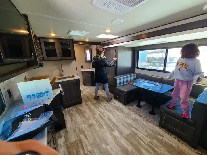 Exploring a spacious RV rental interior, featuring a kitchen, dinette, and an RV starter kit. Great for family travel.. Grand Design Transcend Xplor 2022