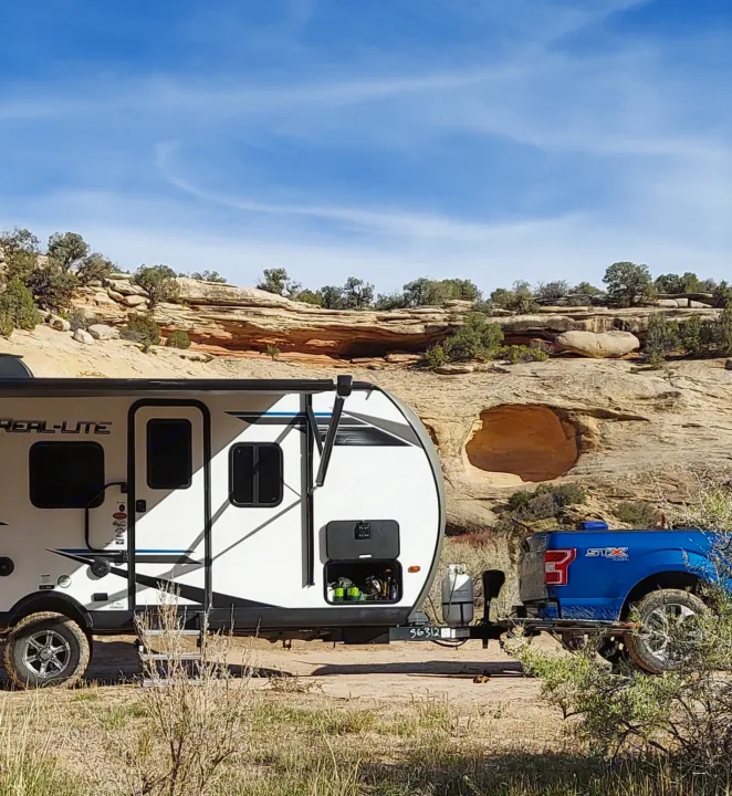 RV rental adventure: Travel trailer & truck parked for off-grid camping amidst stunning desert rock formations.. Forest River Palomino Real-Lite Mini 2021