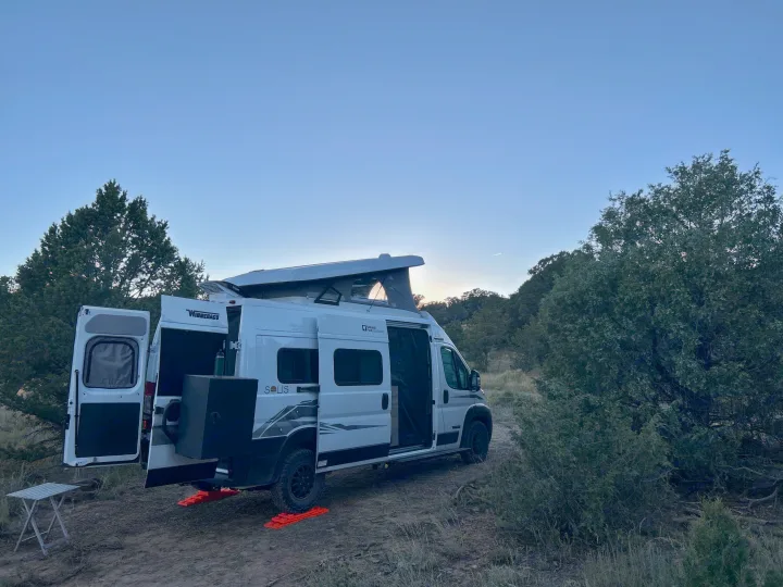 Scenic RV rental: White Winnebago Solis camper van parked with pop-top raised for a peaceful outdoor camping trip.. Winnebago Solis 2023