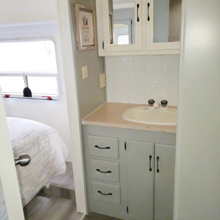 RV rental interior: Updated vanity with sink & cabinets, and bedroom with a window. Clean, functional space.. Damon Corporation Daybreak 2002