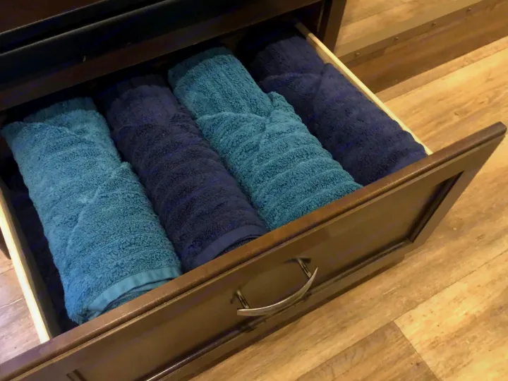 Neatly rolled blue and navy towels in an RV rental drawer, ready for your comfortable stay.. Thor Freedom Elite 2017
