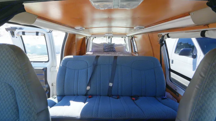 Spacious rv rental camper van interior with comfy bed, ready for adventure. Ideal for road trips.. Chevrolet Other 2006