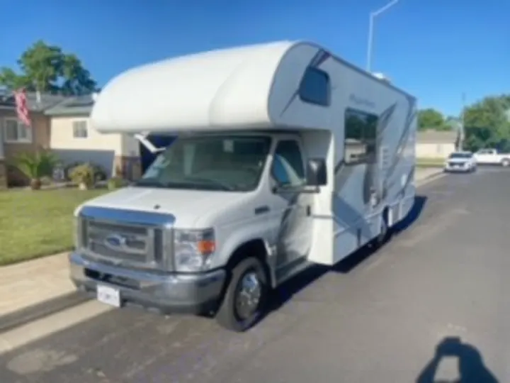 White Class C RV rental parked on a sunny street, ready for road trips & outdoor adventures. Great for RV travel!. Thor Four Winds 2020
