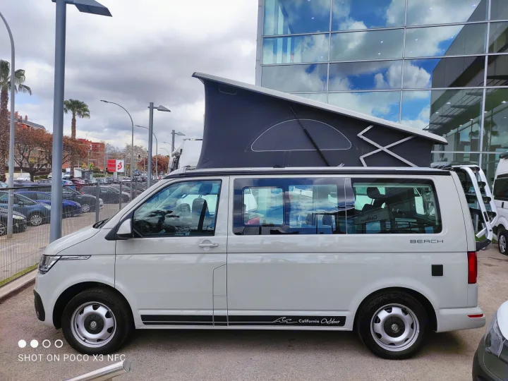 White VW California camper van with a pop-top roof, ideal for RV rental adventures.. Volkswagen California Beach Camper 2.0 TDI 2023