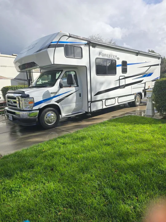 White Class C Forester RV rental parked on a paved pad with green grass, ready for your next travel adventure.. Forester Classic 2023