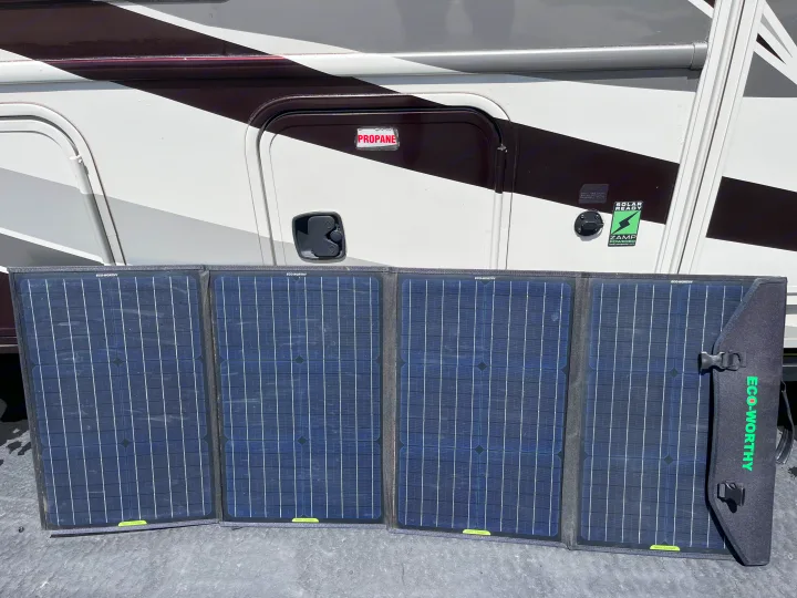 Portable ECO-WORTHY solar panels, unfolded on the ground, are ready to charge an RV rental for off-grid power.. Forest River Sunseeker MBS 2016