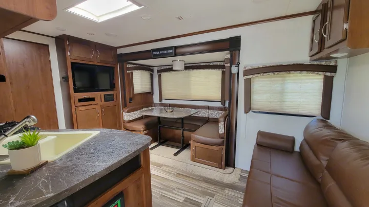 Spacious RV rental interior featuring a full kitchen, dining dinette, and comfortable sofa, perfect for family trips.. jayco Jayflight 2017