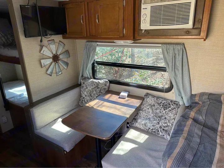 Inside this RV rental: a cozy dinette, bunks, and AC. Enjoy comfortable camper living on your next trip.. Keystone RV Summerland Mini 2017