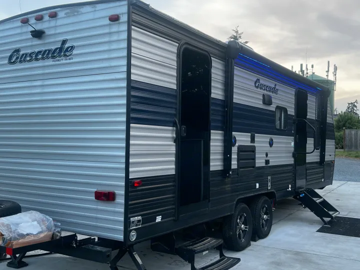 Experience camping in this gray and black Cascade Forest River travel trailer RV rental, featuring an awning with blue lights.. Forest River Cherokee Grey Wolf 2021