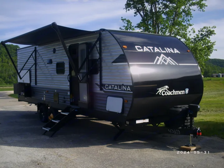 This sleek Coachmen Catalina RV rental, a modern travel trailer with extended awning, awaits your next adventure.. COACHMAN CATALINA 261BHS 2024
