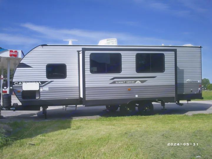 A modern grey Coachmen Catalina Summit Series travel trailer, ideal for your next rv rental, parked near a Cenex station.. COACHMAN CATALINA 261BHS 2024