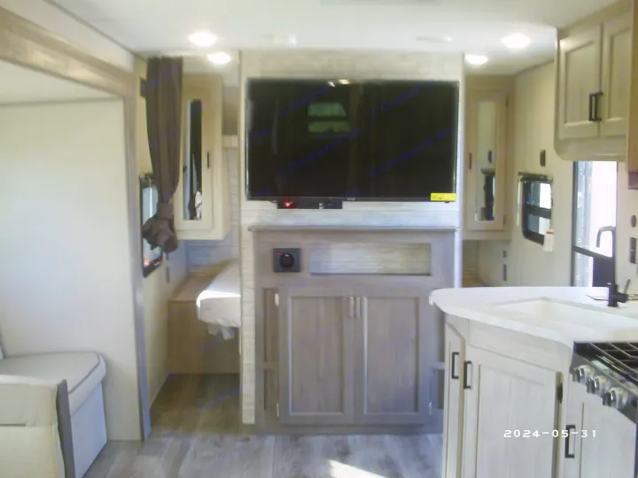 RV rental interior: modern living space with TV, built-in storage, kitchen, and seating area for comfort.. COACHMAN CATALINA 261BHS 2024