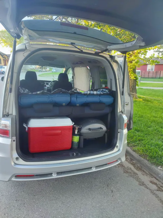 Rear of minivan packed for camping: sleeping pads, cooler, grill ready for an RV rental adventure.. Universal Transformer 2009