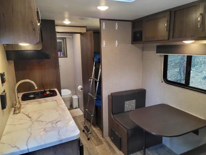 Inside an rv rental: functional space with kitchenette, dinette, private bathroom, and bunk beds.. Jayco Jay Flight SLX Baja Edition 2021
