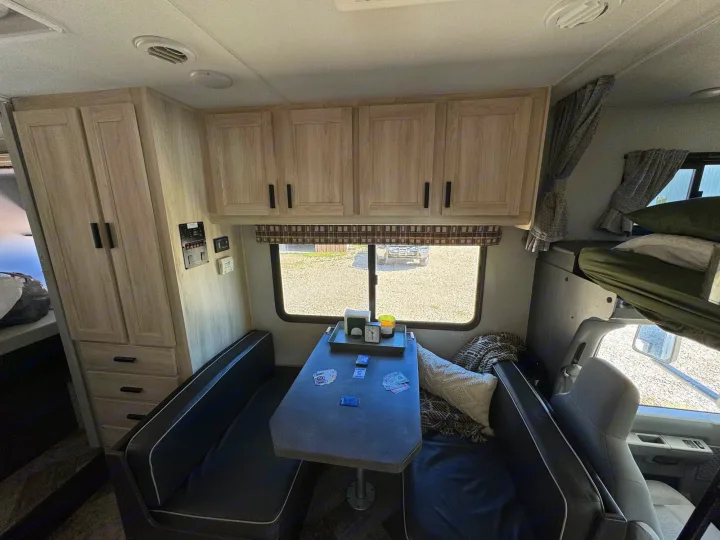 Comfortable RV rental interior featuring a dinette, overhead cabinets, and bunk beds. Perfect for travel.. Forest River Sunseeker LE 2021