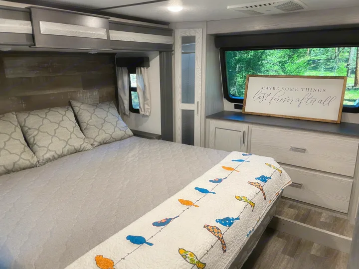 Modern RV rental bedroom with a comfy bed, stylish storage, and nature views. Ideal for a relaxing journey.. Keystone RV Montana High Country 2021