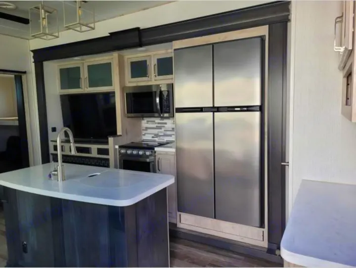 This RV rental boasts a stylish kitchen with island sink, stainless appliances, and a TV in the living area.. Keystone RV Avalanche 2021