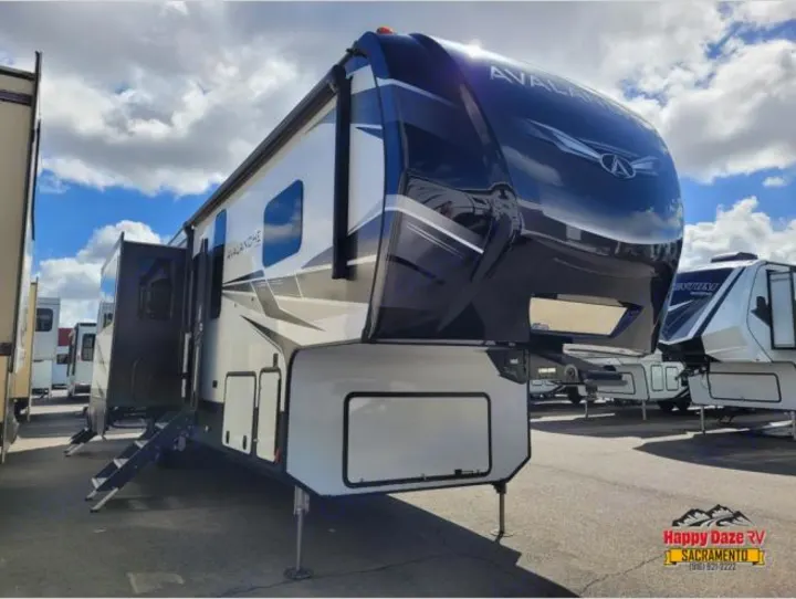 A large white and black Avalanche fifth-wheel RV with extended slides and stairs, ideal for an rv rental.. Keystone RV Avalanche 2021