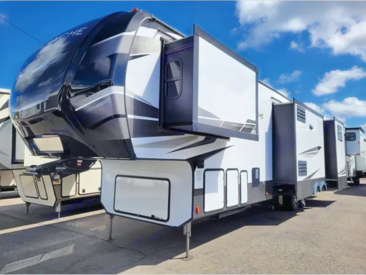 This sleek, black and white fifth-wheel RV, featuring extended slide-outs for spacious living, is ready for your next RV rental trip.. Keystone RV Avalanche 2021