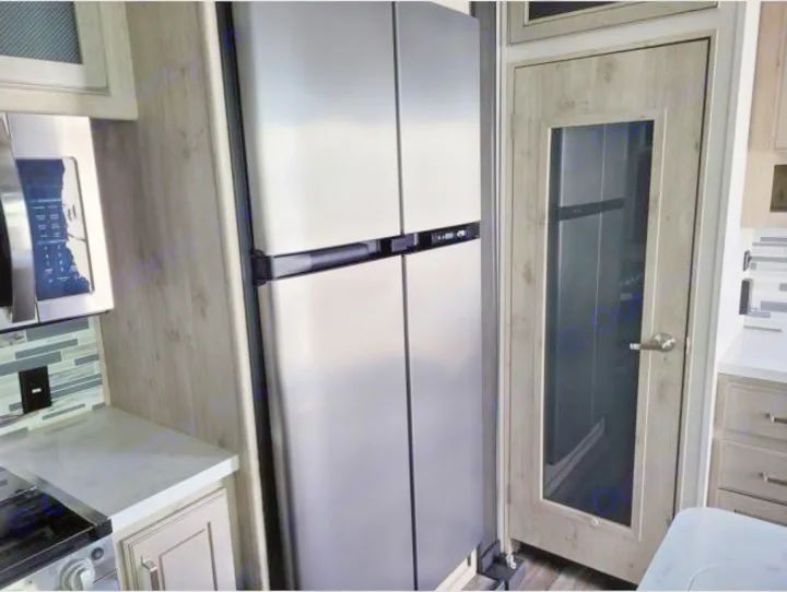 See this RV rental's modern kitchen: stainless steel refrigerator, microwave, tiled backsplash, and wood door.. Keystone RV Avalanche 2021