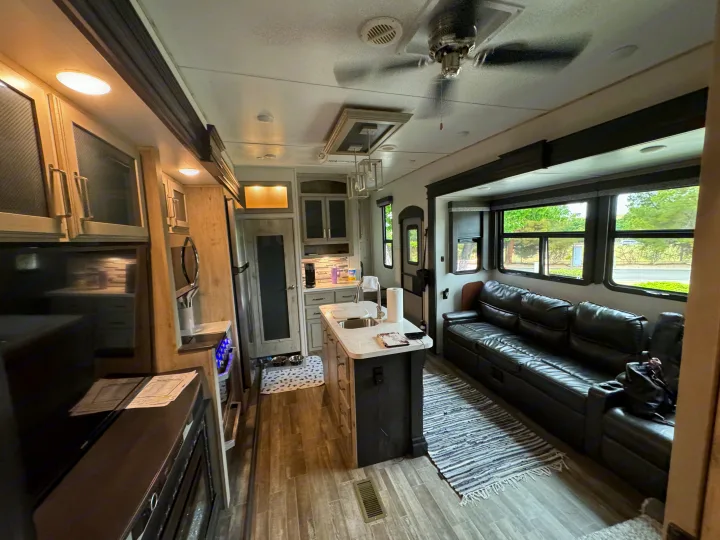 Experience comfort in this RV rental! Bright kitchen, cozy living space with leather sofa, and wood-look floors for your journey.. Keystone RV Avalanche 2021
