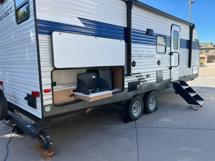 Spacious rv rental travel trailer with an outdoor kitchen, sink, stove, and mini-fridge, ready for adventure.. Prime Time Avenger 24 BHS 2023
