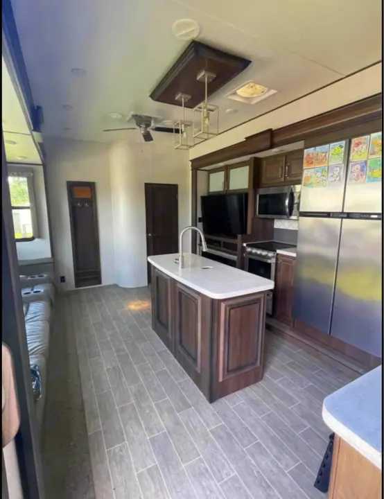 RV rental: Spacious, modern kitchen & living area featuring an island, full appliances, and sofa seating.. Keystone RV Avalanche 2021