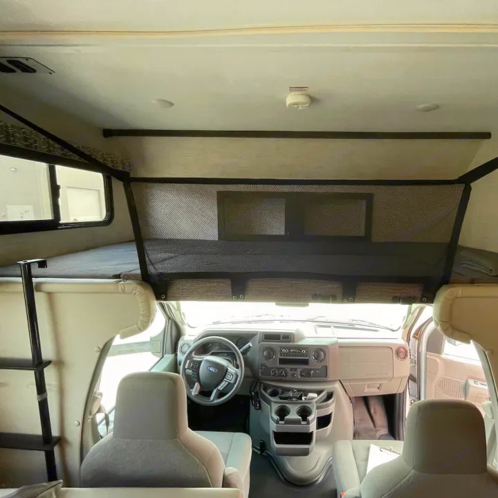Inside this RV rental, view the front cockpit, ample seating, and the ladder to the large overhead bunk.. Gulf Stream Conquest 2022