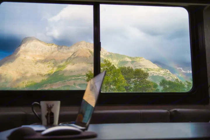 RV rental view: Majestic mountains, a bright rainbow, and a comfy workspace with a laptop. Enjoy nature & work on the go!. Jayco Jay Flight 2022