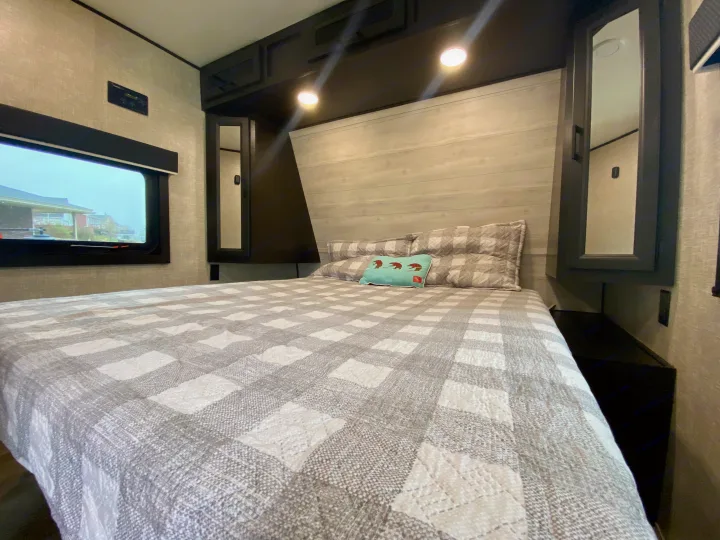 Cozy RV rental bedroom with plaid bed, window, and storage. Perfect for road trips!. Jayco Jay Flight 2022