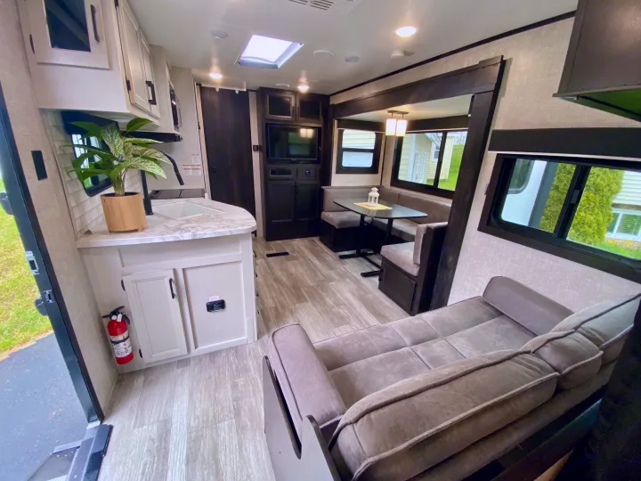 Modern RV rental interior: well-appointed kitchen, comfortable dinette, and sofa for a cozy living space.. Jayco Jay Flight 2022