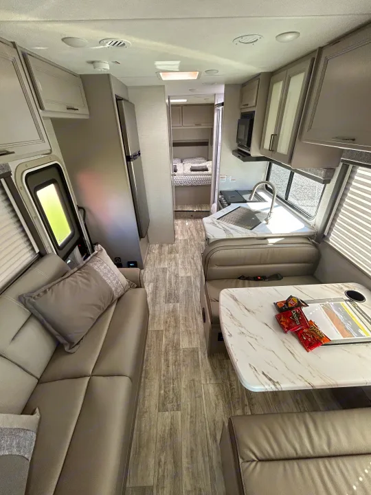 Spacious and modern RV rental interior featuring a full kitchen, comfortable living area, and private bedroom.. Thor Motor Coach Chateau 2024