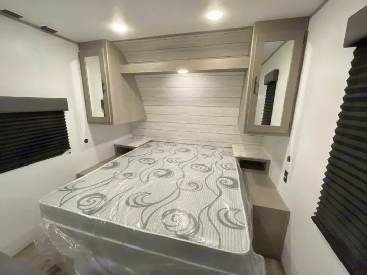 Spacious RV rental bedroom with new mattress, overhead storage, and modern design.. Coleman LT 274BH 2024