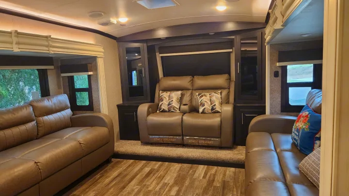 Comfortable RV rental interior with reclining seats, sofas, and wood-look flooring, perfect for your next trip.. Jayco North Point 2021