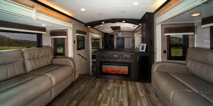 Experience comfort in this spacious RV rental interior, featuring opposing sofas, a cozy fireplace, and scenic window views.. Jayco North Point 2021